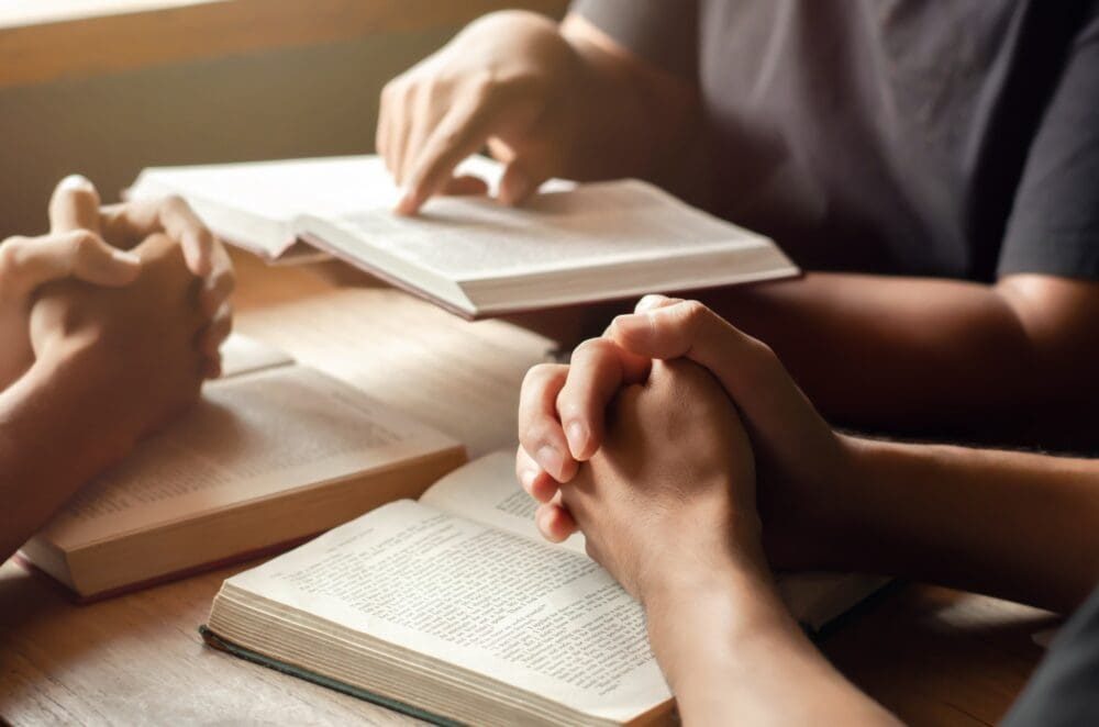 Young Christians join together in prayer and seeking blessings from God. By reading the Bible